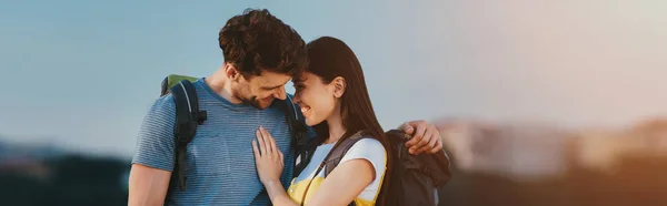 Plan panoramique de bel homme et femme asiatique souriant et étreignant à l'extérieur — Photo de stock