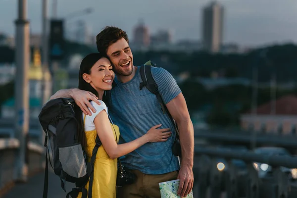 Schöner Mann und asiatische Frau umarmen und wegschauen — Stockfoto
