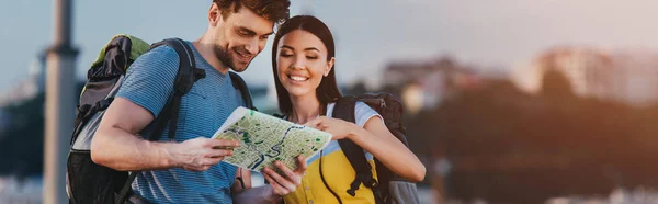 Panoramic shot of handsome man and asian woman looking at map — Stock Photo