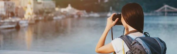 Plan panoramique de femme brune avec sac à dos prenant des photos — Photo de stock