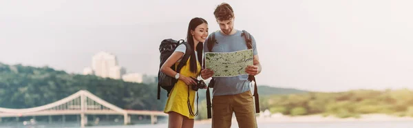 Panoramic shot of handsome man and asian woman looking at map — Stock Photo