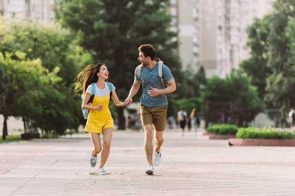 Handsome man and asian woman running and looking at each other — Stock Photo