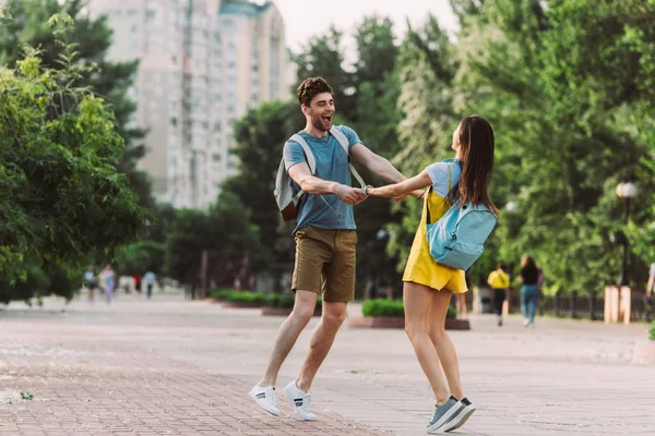 Bell'uomo e donna che sorridono, saltano e si tengono per mano — Foto stock