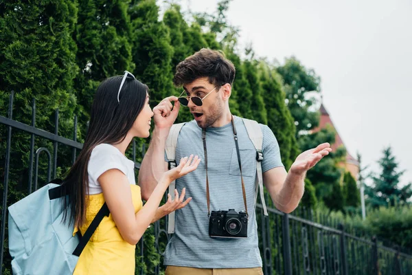 Shocked man and asian woman talking and looking at each other — Stock Photo