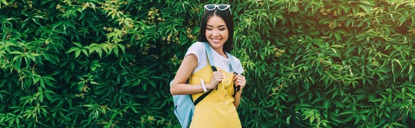 Colpo panoramico di asiatica e attraente donna sorridente e guardando giù — Foto stock