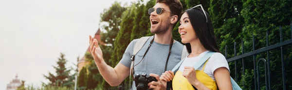 Plan panoramique de choqué homme et asiatique femme regardant loin — Photo de stock