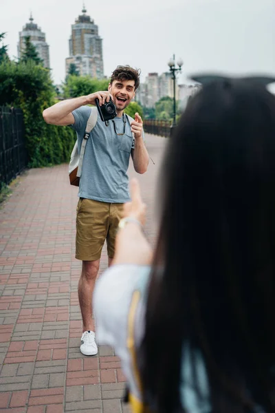 Selective focus of handsome man taking photo of brunette woman — Stock Photo