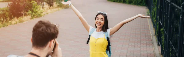 Panoramic shot of man taking photo of brunette and asian woman — Stock Photo