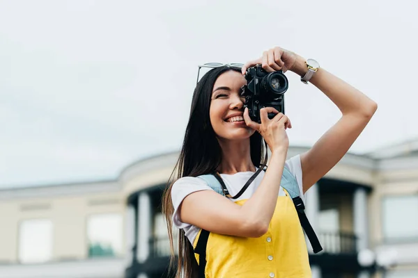 Attraktive asiatische Frau mit Brille, die lächelt und Fotos macht — Stockfoto