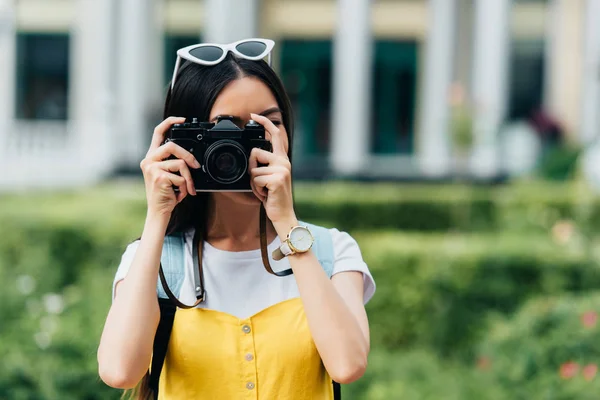 Morena mujer con gafas tomando fotos con la ayuda de la cámara digital - foto de stock