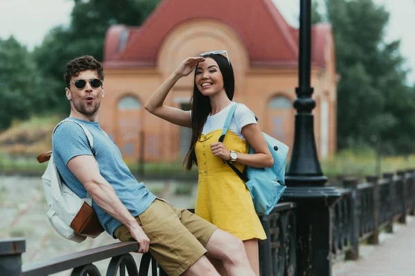 Schöner Mann und asiatische Frau lächeln und schauen weg — Stockfoto