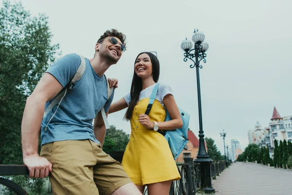 Schöner Mann und asiatische Frau lächeln und schauen weg — Stockfoto