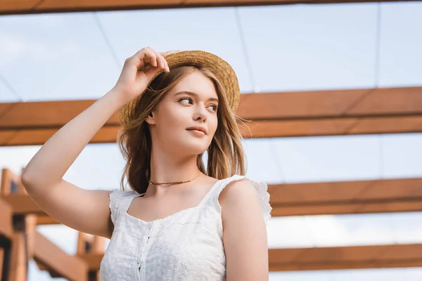 Baixo ângulo vista de menina bonita em chapéu de palha olhando para longe — Fotografia de Stock