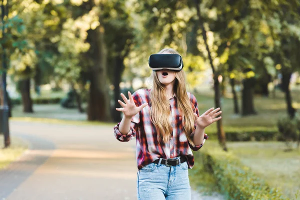 Surpris jeune fille en vêtements décontractés en utilisant vr casque — Photo de stock