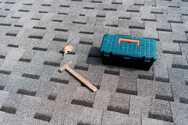 Toolbox near hammer and measuring tape on roof — Stock Photo