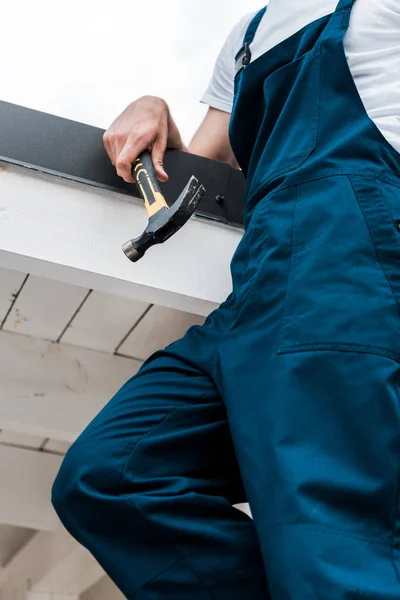 Cropped view of worker in uniform holding hammer — Stock Photo