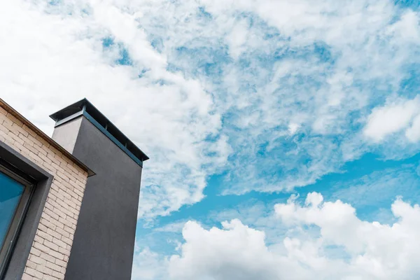 Vue à angle bas du nouveau bâtiment contre le ciel avec nuages — Photo de stock