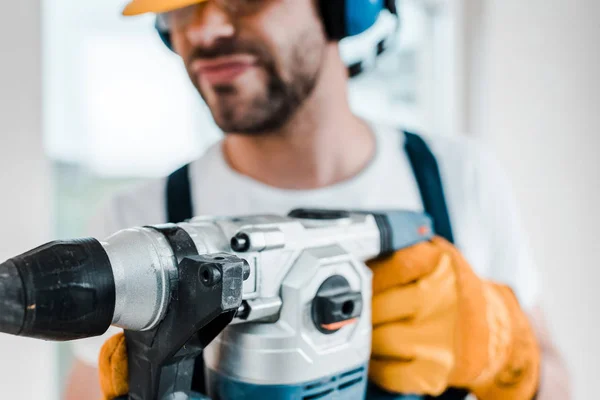 Selective focus of handyman using hammer drill — Stock Photo