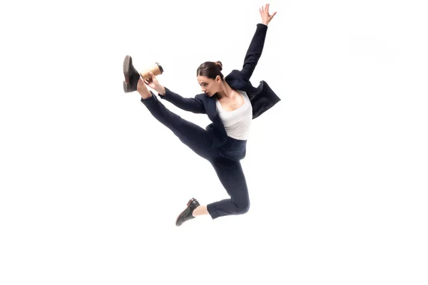 Junge Geschäftsfrau springt beim Tanzen, während sie Pappbecher auf weißem Grund vergoldet — Stockfoto