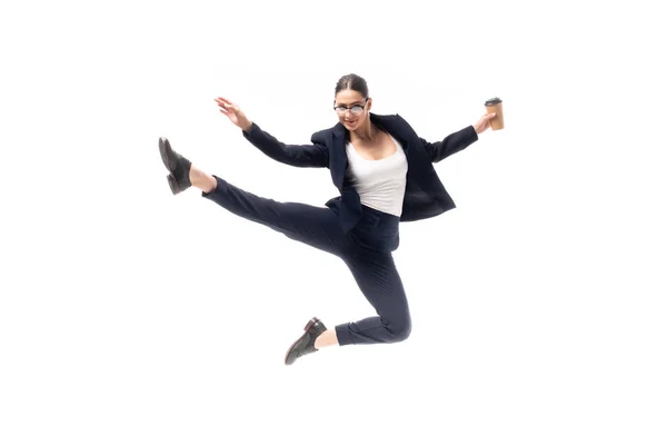 Attraktive Geschäftsfrau blickt in die Kamera, während sie Einwegbecher in der Hand hält und isoliert auf Weiß tanzt — Stockfoto