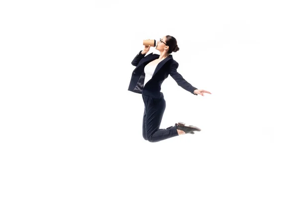 Young businesswoman drinking coffee to go while dancing isolated on white — Stock Photo