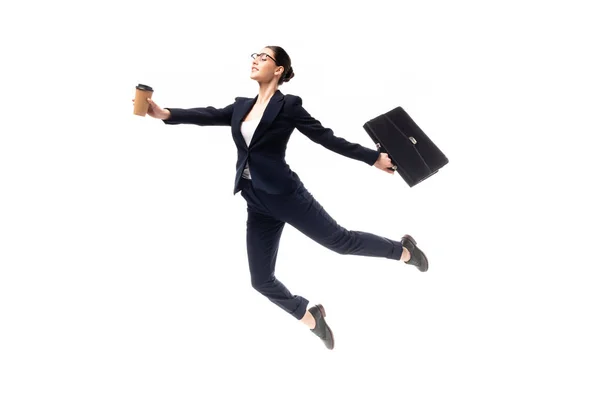 Young attractive businesswoman holding coffee to go and briefcase while levitating isolated on white — Stock Photo