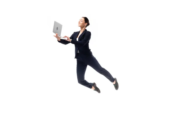 Junge, fröhliche Geschäftsfrau benutzt Laptop, während sie isoliert auf Weiß schwebt — Stockfoto