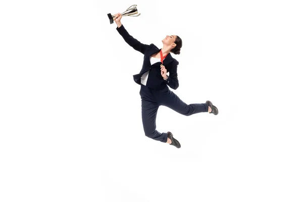 Jovem empresária com medalha e troféu copo pulando em dança isolada em branco — Fotografia de Stock