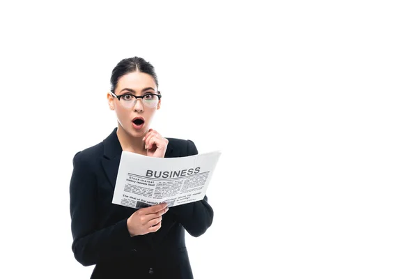 Шокована бізнес-леді дивиться на камеру, тримаючи бізнес-газету ізольовано на білому — стокове фото
