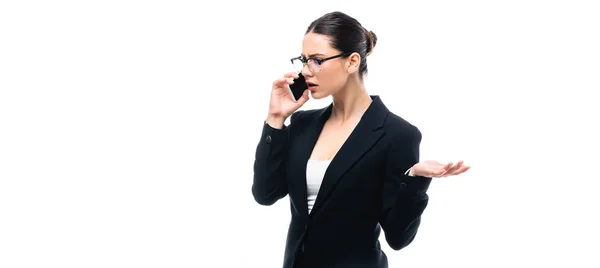 Panoramic shot of displeased businesswoman talking on smartphone isolated on white — Stock Photo