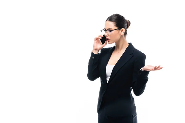 Недовольная деловая женщина жестикулирует, разговаривая на смартфоне изолированы на белом — стоковое фото