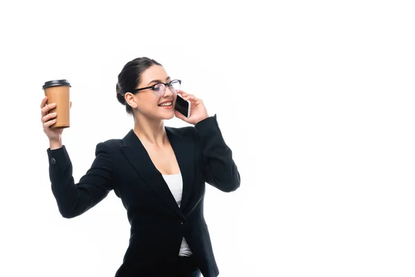 Glückliche Geschäftsfrau, die auf dem Smartphone spricht, während sie Kaffee in der Hand hält, um auf Weiß zu gehen — Stockfoto