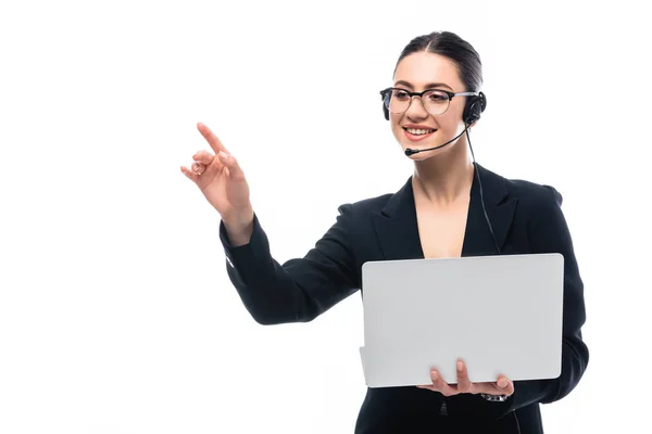 Fröhliche Callcenter-Betreiber in Headset zeigt mit dem Finger, während Laptop isoliert auf weiß — Stockfoto