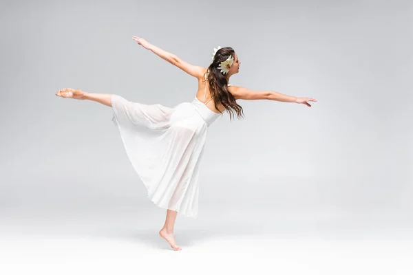 Schöne, elegante Ballerina im weißen Kleid, die auf grauem Hintergrund tanzt — Stockfoto