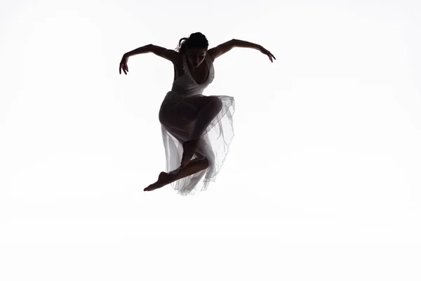 Junge, anmutige Ballerina springt im Tanz vereinzelt auf Weiß — Stockfoto