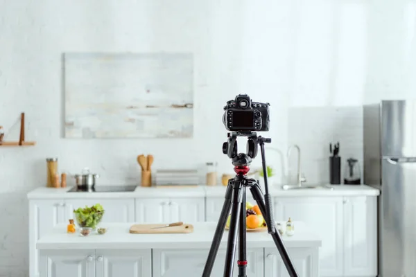 Enfoque selectivo de la cámara digital en el trípode en la cocina moderna - foto de stock