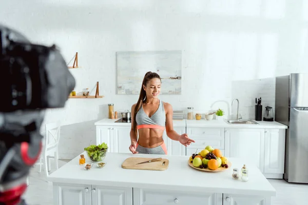 Foco seletivo do blogueiro de vídeo feliz apontando com o dedo para frutas — Fotografia de Stock