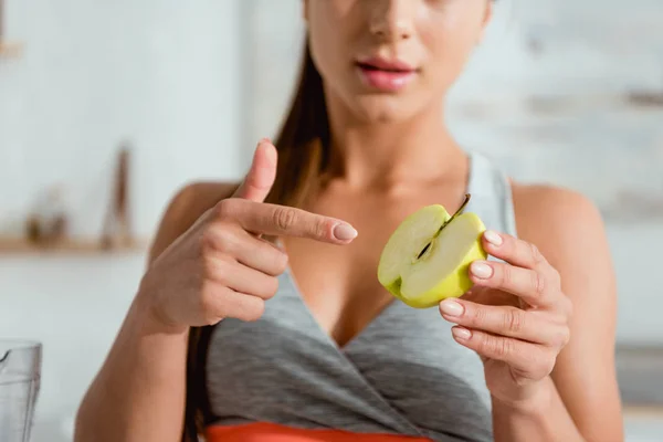 Vue recadrée de la femme pointant du doigt la moitié de la pomme mûre — Photo de stock