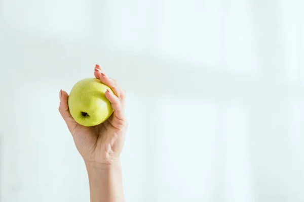 Vista recortada de la mujer sosteniendo manzana orgánica verde - foto de stock