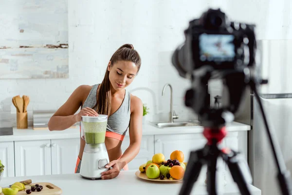 Foyer sélectif de femme gaie préparant smoothie dans le mélangeur — Photo de stock