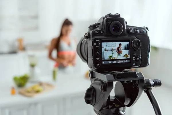 Вибірковий фокус цифрової камери з дівчиною біля скла з напоєм і фруктами на екрані — стокове фото