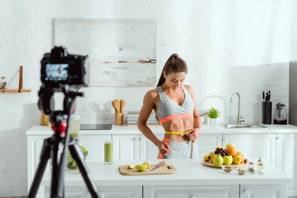 Selective focus of girl measuring waist near fruits and — Stock Photo