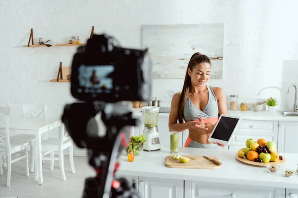 Foco seletivo do blogueiro de vídeo apontando com o dedo para tablet digital com tela em branco — Fotografia de Stock