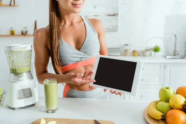 Abgeschnittene Ansicht eines glücklichen Mädchens gestikuliert, während es ein digitales Tablet mit leerem Bildschirm hält — Stockfoto