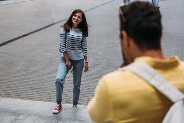 Enfoque selectivo del hombre bi-racial cerca de la mujer feliz fuera - foto de stock