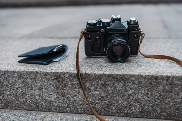 Black wallet with cash near modern digital camera on stairs — Stock Photo