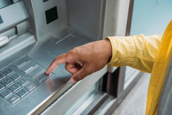 Vista ritagliata di uomo bi-razziale premendo il pulsante sulla tastiera ATM — Foto stock