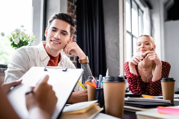 Selektiver Fokus dreier multiethnischer Freunde, die lächeln und wegschauen — Stockfoto