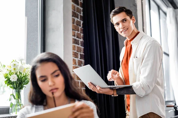 Selektiver Fokus der hübschen Studentin, die Laptop hält und wegschaut — Stockfoto