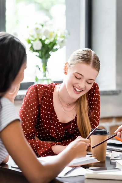 Selective focus of attractive multiethnic students smiling in apartment — Stock Photo